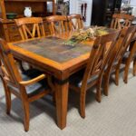 A dining room table with chairs and a hutch.