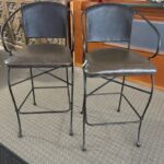 Two metal chairs with leather seats and backs.