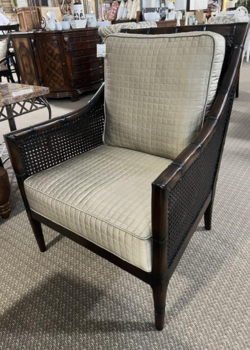 Cane-sided dark wood armchair with quilted cushions