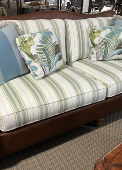 Leather-base sofa with striped tropical throw pillows