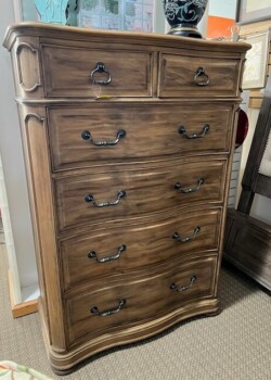 Wooden chest of drawers with curved design.