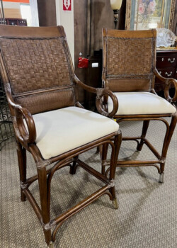 Two wooden bar stools with cushions.