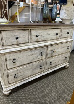 Vintage wooden dresser with multiple drawers.